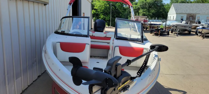 Slide: The Image of 2016 Tahoe 450 TF boat with red and white seating, docked outdoors. - 12