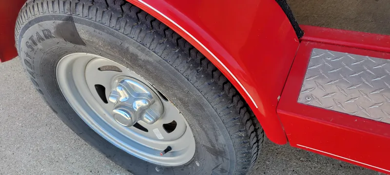 Slide: The Image of Close-up of a 2016 Tahoe 450 TF trailer tire and red fender with diamond plate step. - 16