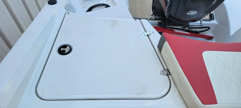 Slide: The Image of 2016 Tahoe 450 TF boat deck with red and white seating, featuring storage compartment and motor. - 21