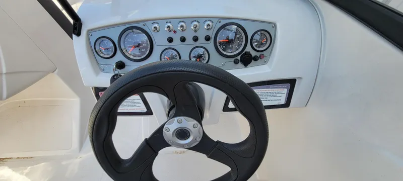 Slide: The Image of Steering wheel and dashboard of 2016 Tahoe 450 TF boat with gauges and controls. - 27