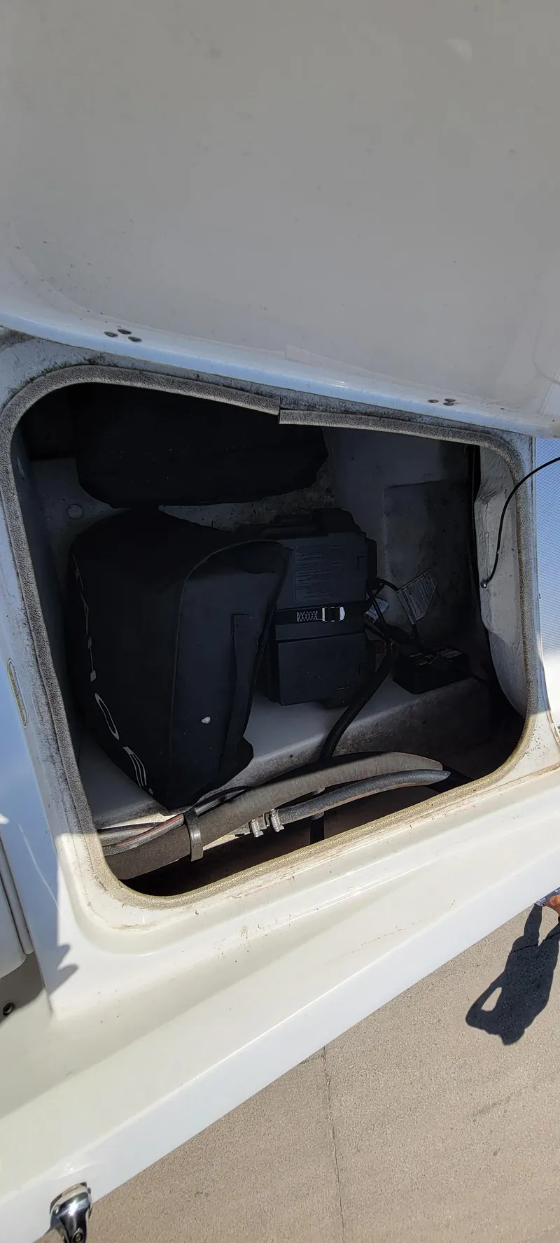 Slide: The Image of Storage compartment of a 2016 Tahoe 450 TF boat, containing equipment and a battery. - 30
