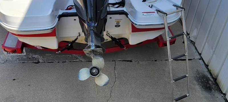 Slide: The Image of 2016 Tahoe 450 TF boat stern with propeller and boarding ladder on concrete surface. - 7