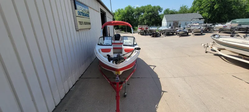 Slide: The Image of 2016 Tahoe 450 TF boat in a marina, surrounded by other boats and greenery. - 8