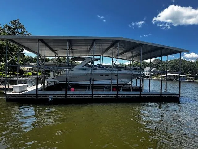 The Image of 2004 Regal Commodore 4260 yacht docked under a covered marina on a sunny day. - 0