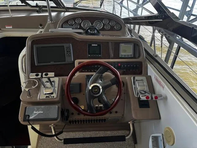 Slide: The Image of 2004 Regal Commodore 4260 boat dashboard with steering wheel and navigation controls. - 13