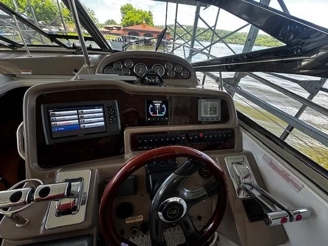 Slide: The Image of 2004 Regal Commodore 4260 helm with modern controls and scenic water view. - 16