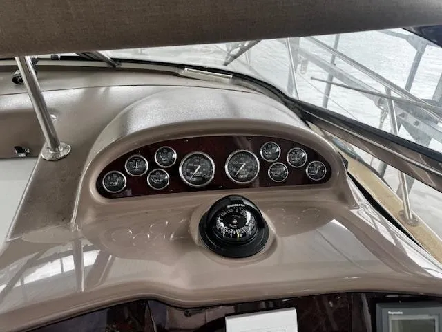 Slide: The Image of 2004 Regal Commodore 4260 dashboard with gauges and compass, showcasing boat's control panel. - 18