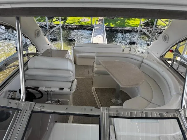 Slide: The Image of 2004 Regal Commodore 4260 yacht interior with seating and table, docked by the water. - 27