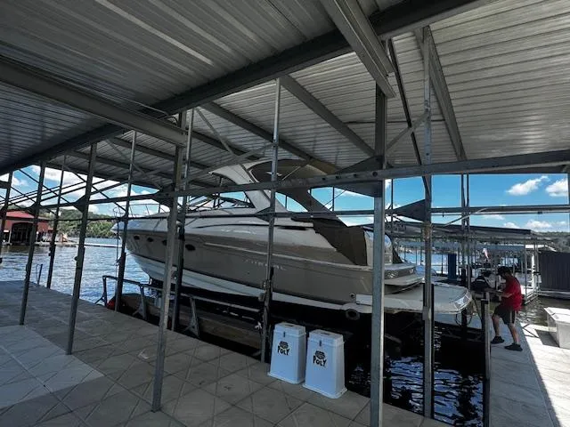 Slide: The Image of 2004 Regal Commodore 4260 yacht docked under a metal canopy by the water. - 3