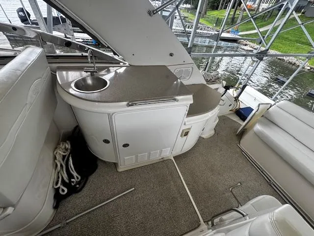 Slide: The Image of 2004 Regal Commodore 4260 yacht interior with sink, seating, and water view. - 32