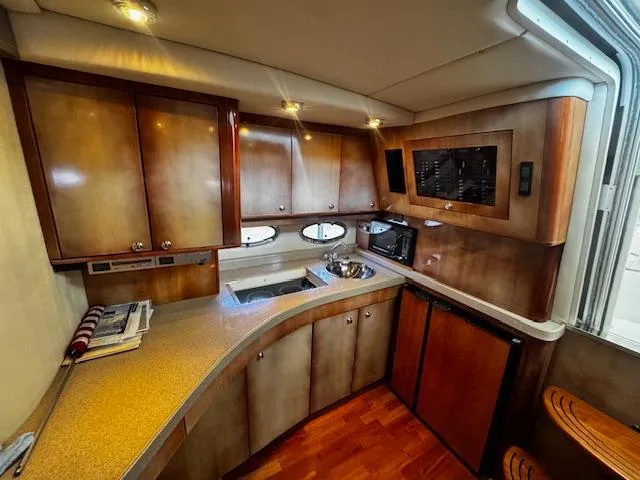 Slide: The Image of Luxurious 2004 Regal Commodore 4260 yacht kitchen with wood cabinets and modern appliances. - 39