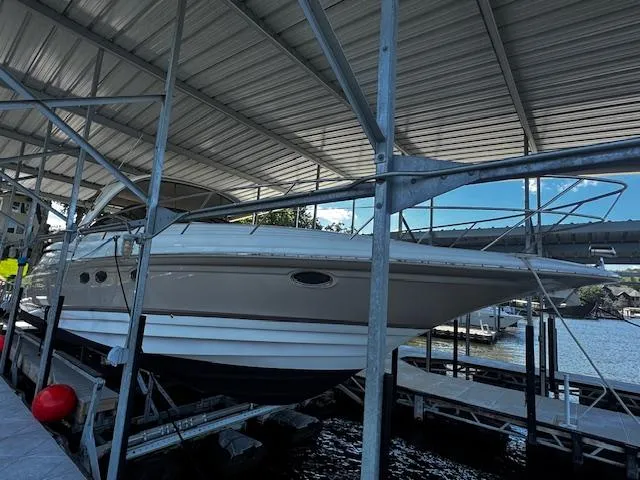 Slide: The Image of 2004 Regal Commodore 4260 yacht docked under a metal canopy. - 4