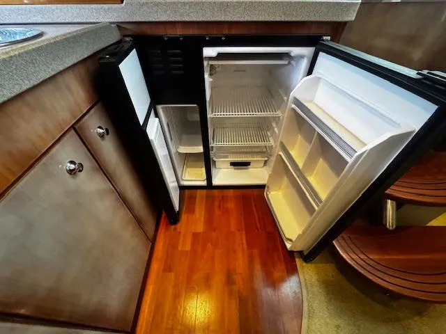 Slide: The Image of Open refrigerator in 2004 Regal Commodore 4260 yacht kitchen with wooden flooring. - 44