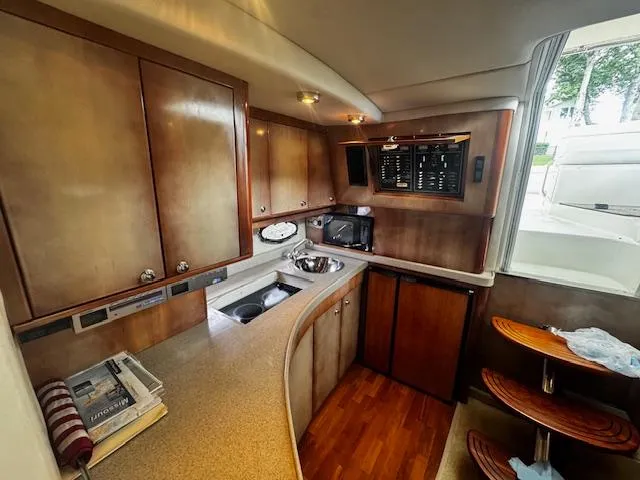 Slide: The Image of 2004 Regal Commodore 4260 yacht interior kitchen with wood cabinets and modern appliances. - 46