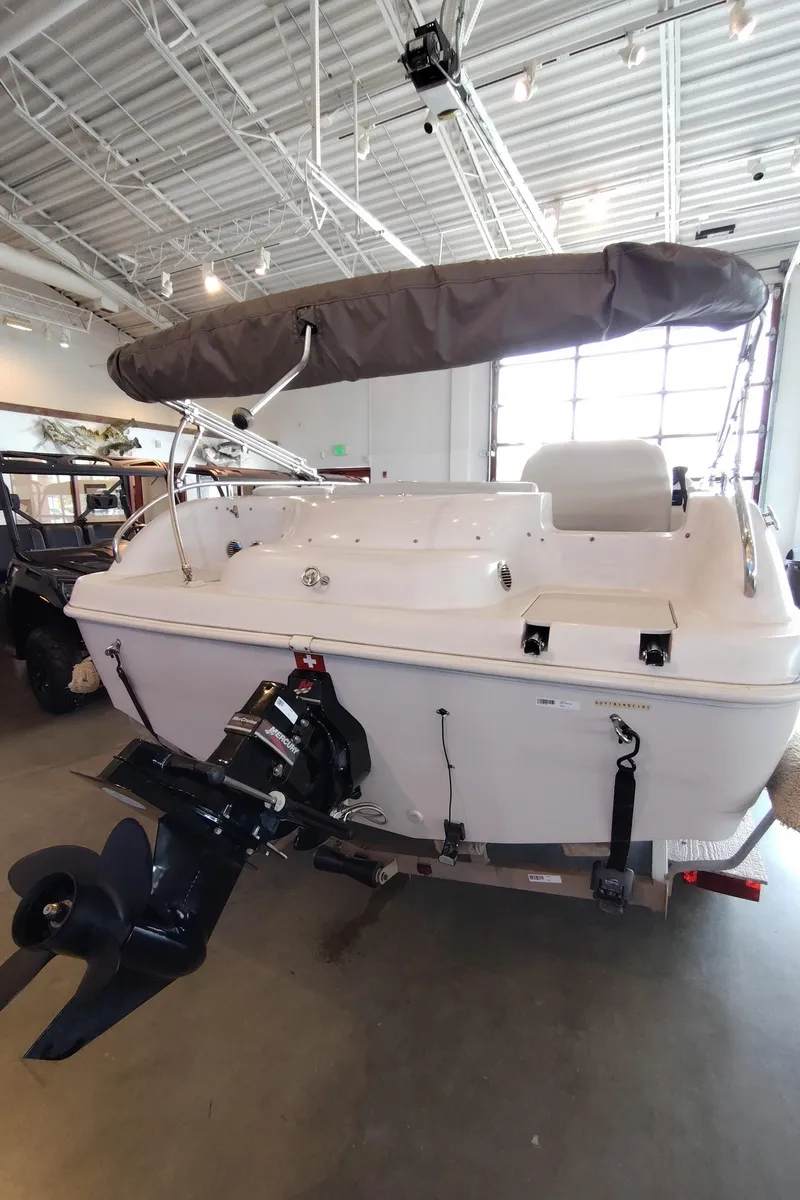 Slide: The Image of 2001 Hurricane 201GS boat with canopy and outboard motor in a showroom. - 19
