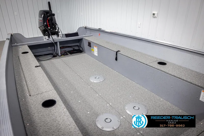 Slide: The Image of 2025 Lund 1600 Fury Heritage Edition boat interior with Mercury engine, showcased in a showroom. - 16