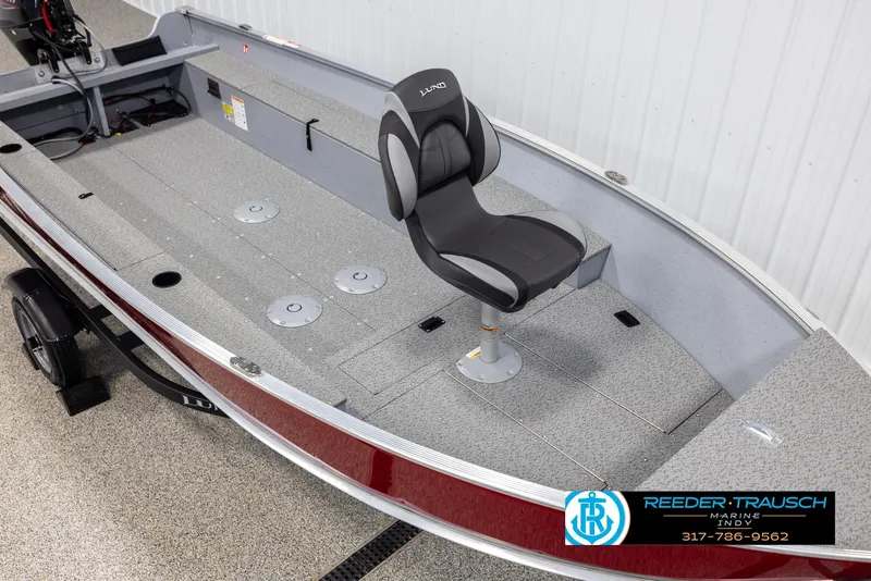 Slide: The Image of 2025 Lund 1600 Fury Heritage Edition boat interior with swivel seat, gray flooring, and red exterior. - 7