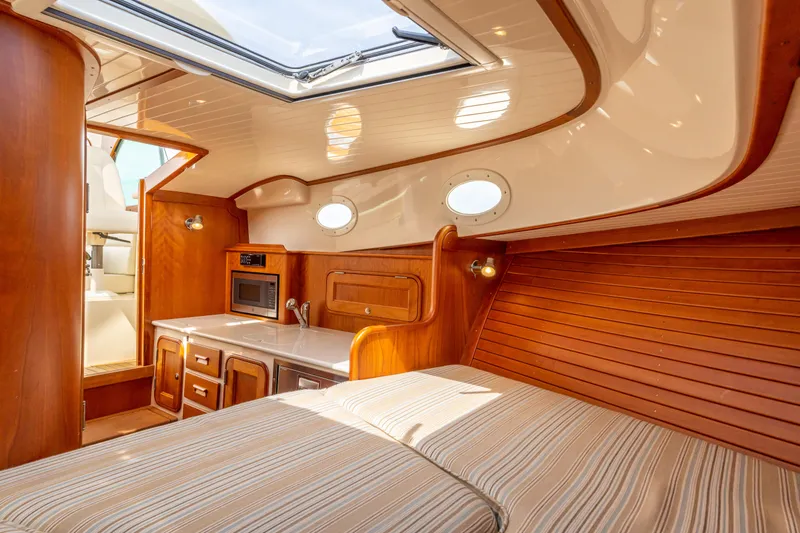 Slide: The Image of Interior of 2018 Hinckley Picnic Boat MKII with wood finish and compact kitchen. - 15