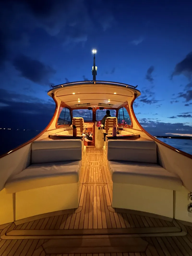 Slide: The Image of 2018 Hinckley Picnic Boat MKII at dusk, featuring elegant seating and ambient lighting. - 3