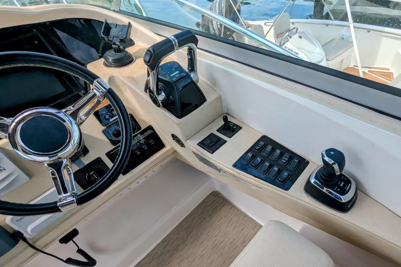 Slide: The Image of Cockpit controls of a 2018 Regal 33 XO boat, featuring steering wheel and throttle. - 14