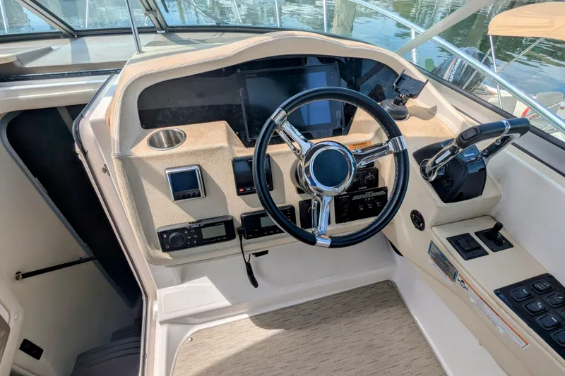 Slide: The Image of Cockpit of 2018 Regal 33 XO boat with steering wheel and control panel. - 15