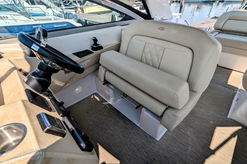 Slide: The Image of Captain's seat and helm of 2018 Regal 33 XO boat, featuring luxurious beige upholstery. - 16