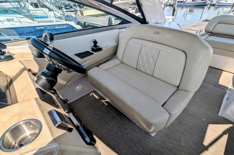 Slide: The Image of 2018 Regal 33 XO boat interior with steering wheel and beige seating. - 17