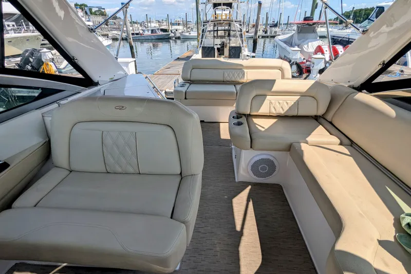 Slide: The Image of Luxurious interior of 2018 Regal 33 XO yacht at marina, featuring beige seating. - 18