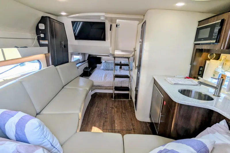 Slide: The Image of 2018 Regal 33 XO yacht interior with modern kitchen, seating, and cozy sleeping area. - 20