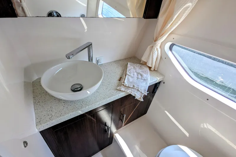 Slide: The Image of Luxurious bathroom interior of 2018 Regal 33 XO yacht with modern sink and window view. - 24