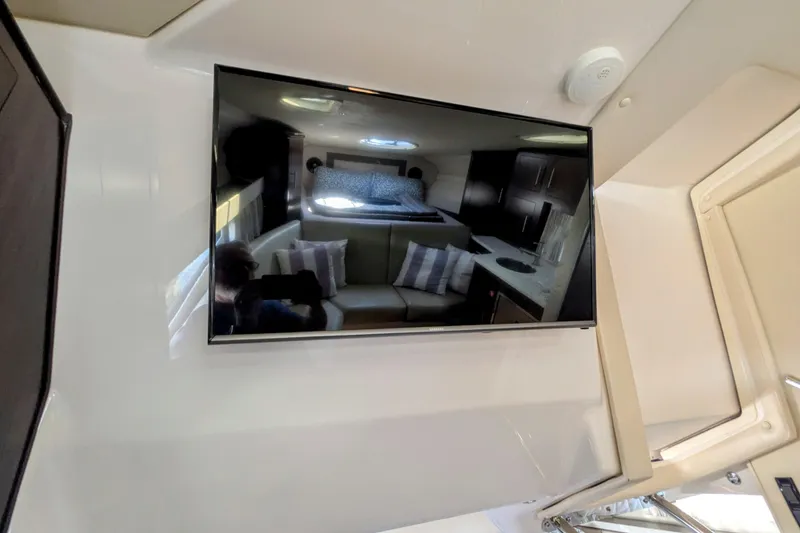 Slide: The Image of Interior of 2018 Regal 33 XO yacht with TV reflecting cozy cabin space. - 28