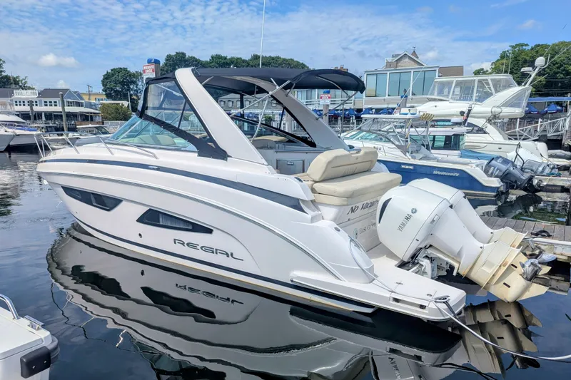 Slide: The Image of 2018 Regal 33 XO boat docked at marina, featuring sleek design and twin outboard engines. - 3