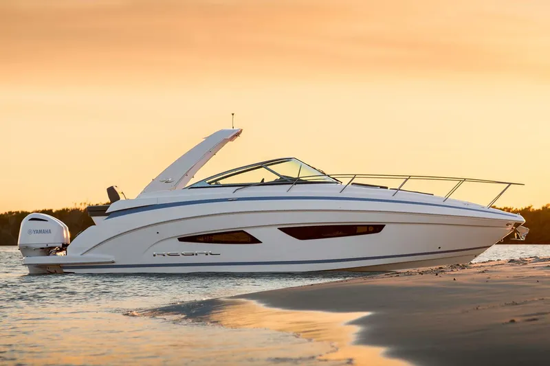 Slide: The Image of Manufacturer Provided Image: 2018 Regal 33 XO boat at sunset on a sandy shore. - 33