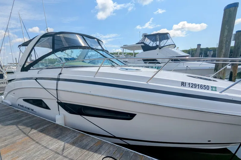 Slide: The Image of 2018 Regal 33 XO boat docked at marina under clear blue sky. - 4