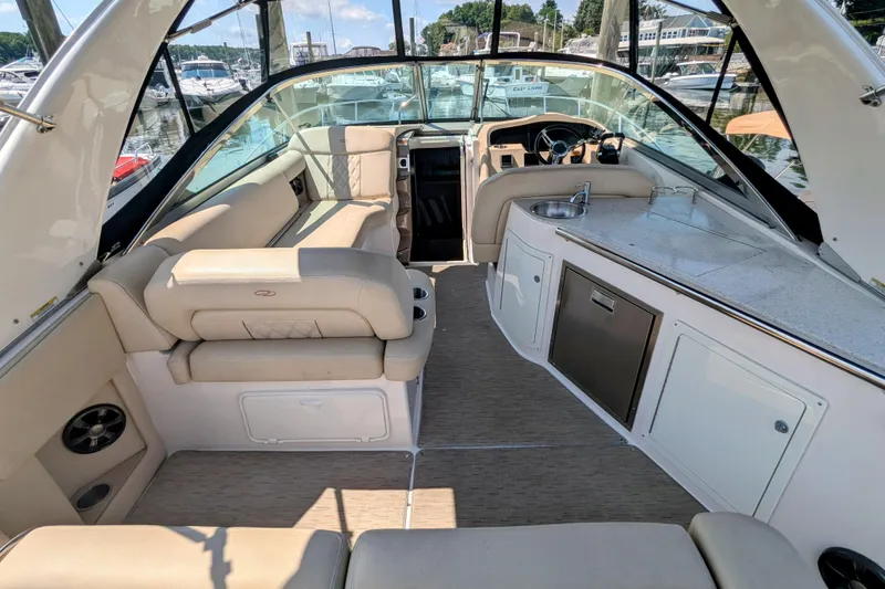 Slide: The Image of 2018 Regal 33 XO boat interior with seating, kitchenette, and helm at marina. - 8