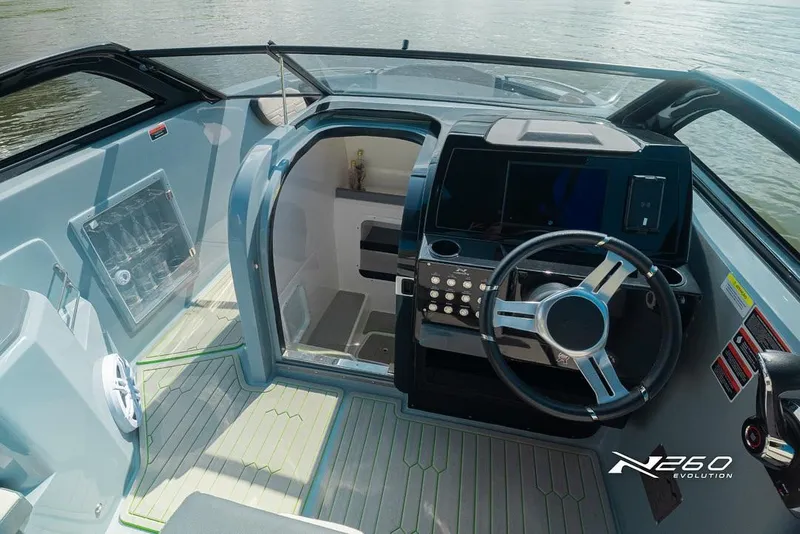 Slide: The Image of 2025 NX Boats NX260 EVOLUTION cockpit with modern steering and control panel on a sunny day. - 4