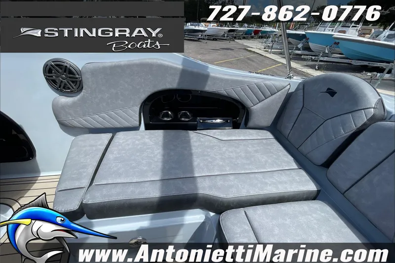 Slide: The Image of 2026 Stingray 23 OSX boat interior with gray seating, speaker, and branding details. - 36