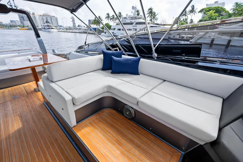 Slide: The Image of Luxurious 2019 Riva 56 Rivale yacht interior with white seating and wooden deck. - 16