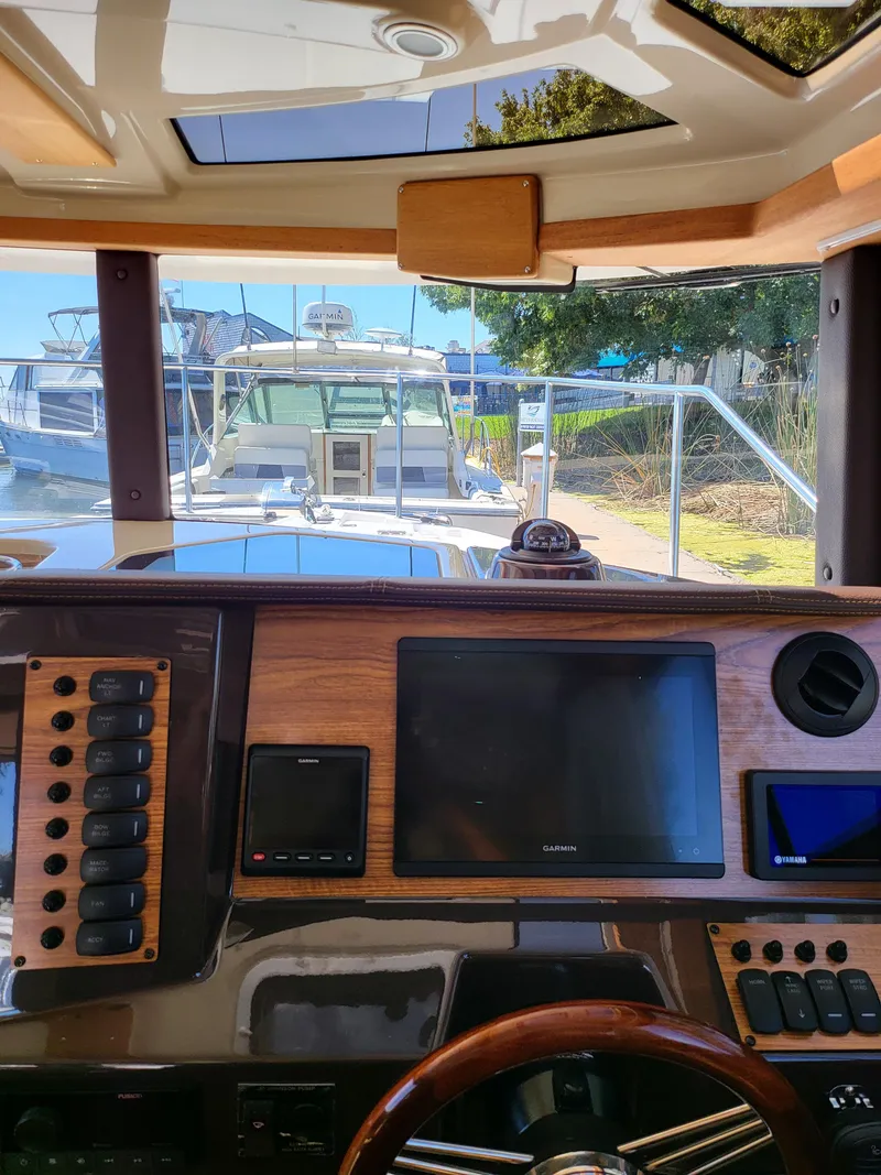 Slide: The Image of Interior view of 2023 Ranger Tugs R-27 helm with navigation screens and controls. - 15