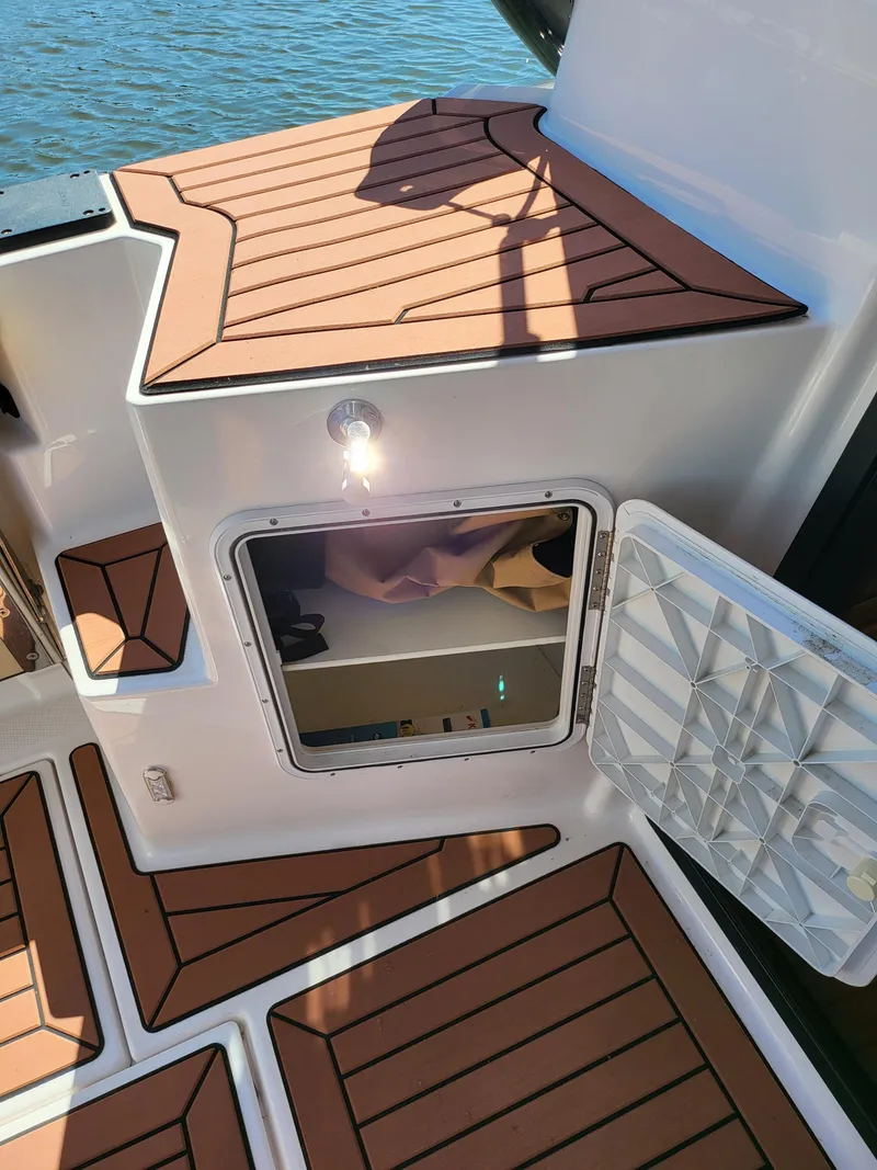 Slide: The Image of 2023 Ranger Tugs R-27 boat deck with open hatch and water view. - 23