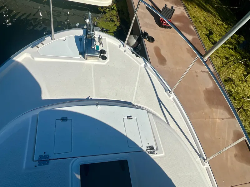 Slide: The Image of 2023 Ranger Tugs R-27 boat deck with railing, docked beside a wooden pier. - 8