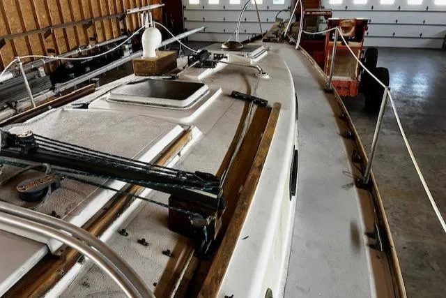 Slide: The Image of 1977 Cape Dory Sloop sailboat deck in storage, showcasing rigging and hatches. - 15