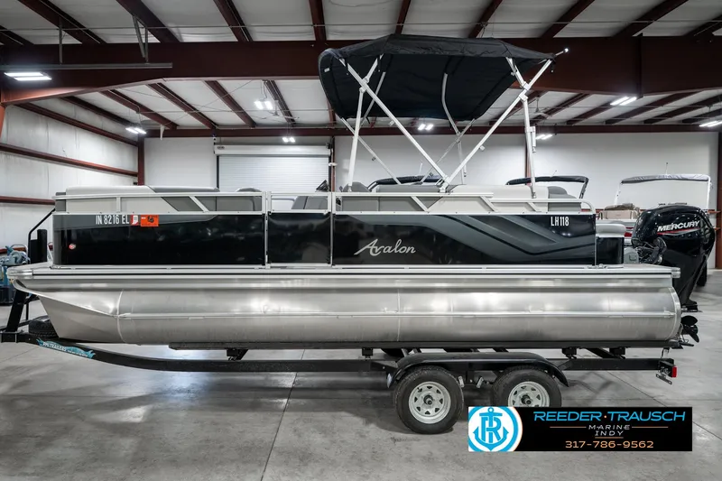 Slide: The Image of 2023 Avalon 2180 Vent CR pontoon boat in showroom, side view with trailer. - 11
