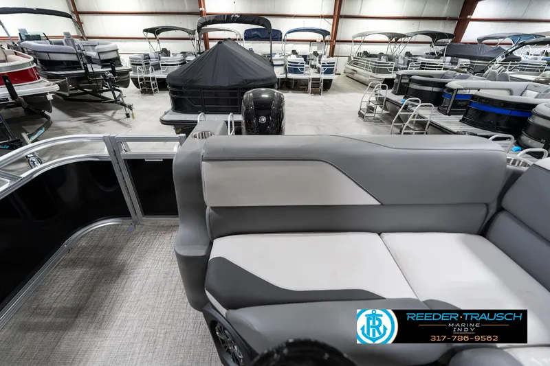 Slide: The Image of 2023 Avalon 2180 Vent CR pontoon boat interior in showroom with multiple boats displayed. - 18