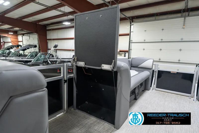 Slide: The Image of 2023 Avalon 2180 Vent CR boat interior in showroom, featuring gray seating and storage. - 24