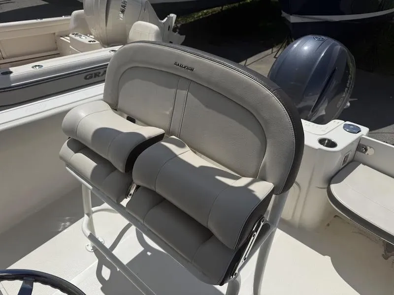Slide: The Image of 2023 Sailfish 220 boat seat with cushioned backrest and armrests, in a sunlit setting. - 10