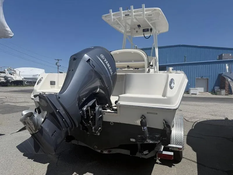 Slide: The Image of 2023 Sailfish 220 boat with Yamaha outboard motor, parked outdoors. - 11