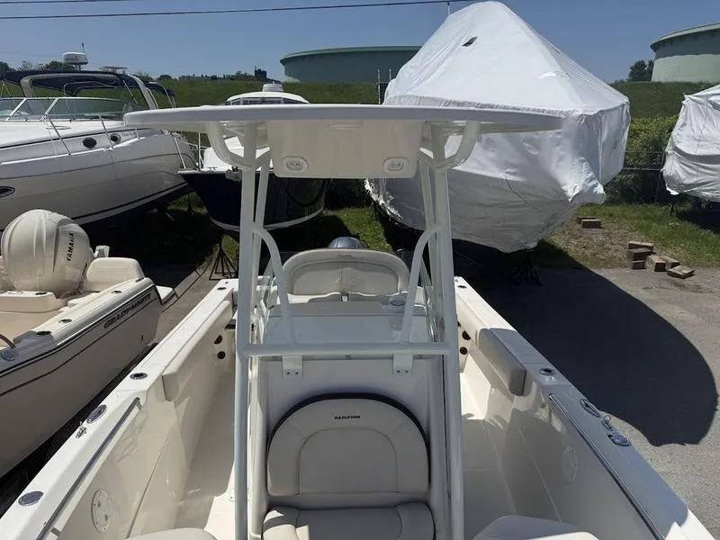 Slide: The Image of 2023 Sailfish 220 boat with T-top, parked among other boats in a marina. - 17