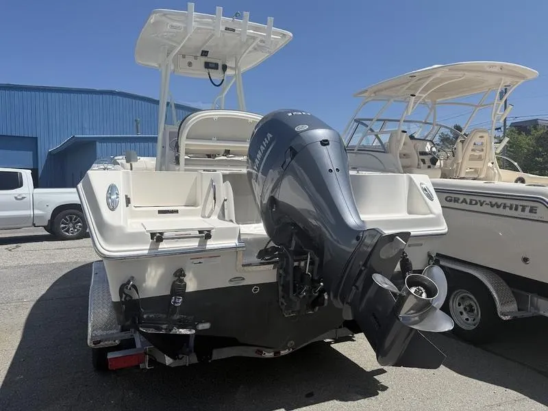 Slide: The Image of 2023 Sailfish 220 boat with Yamaha outboard motor, parked beside a Grady-White boat. - 2