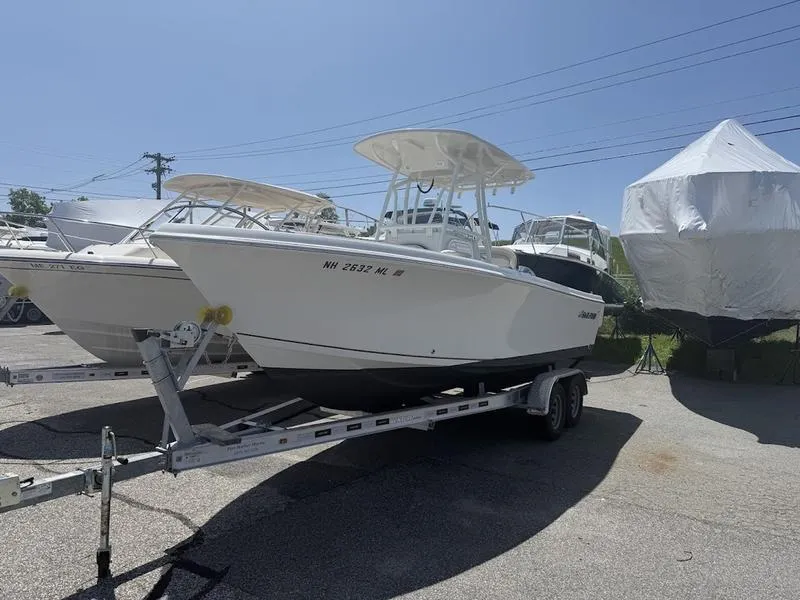 Slide: The Image of 2023 Sailfish 220 boat on trailer in a sunny outdoor setting. - 4